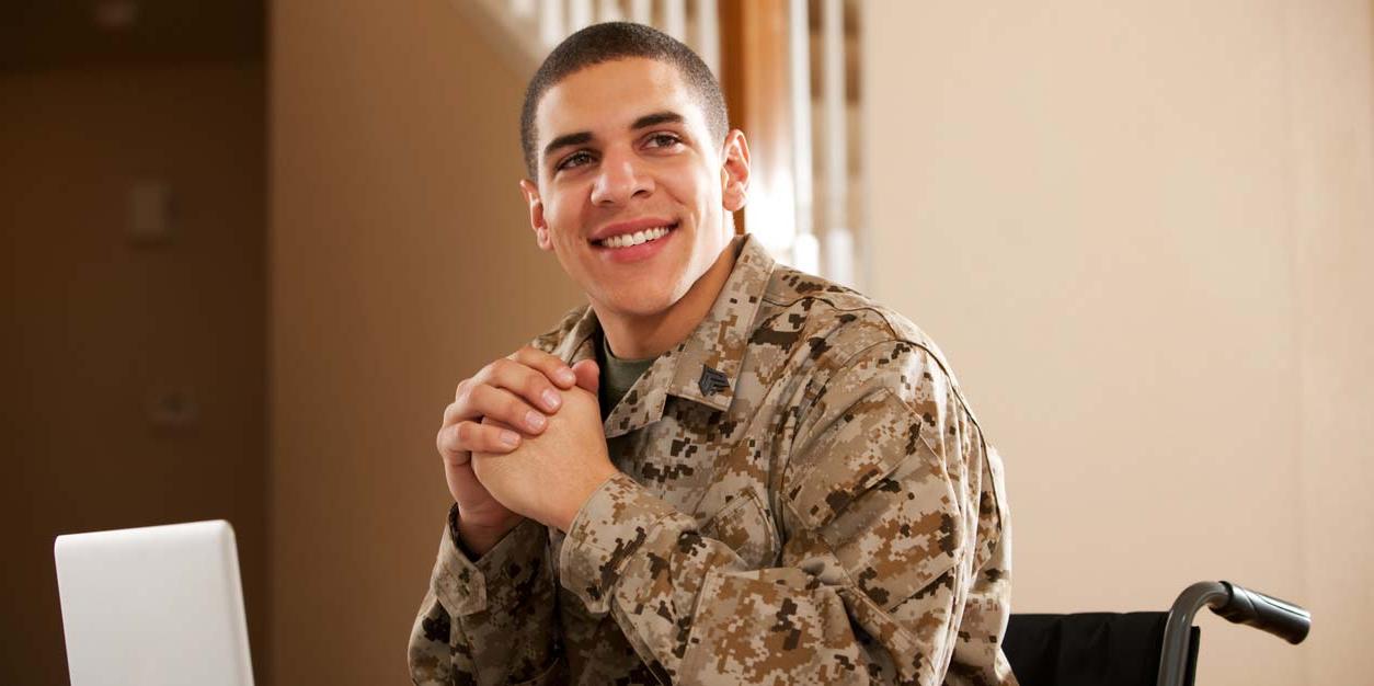 vet in wheelchair smiling at computer